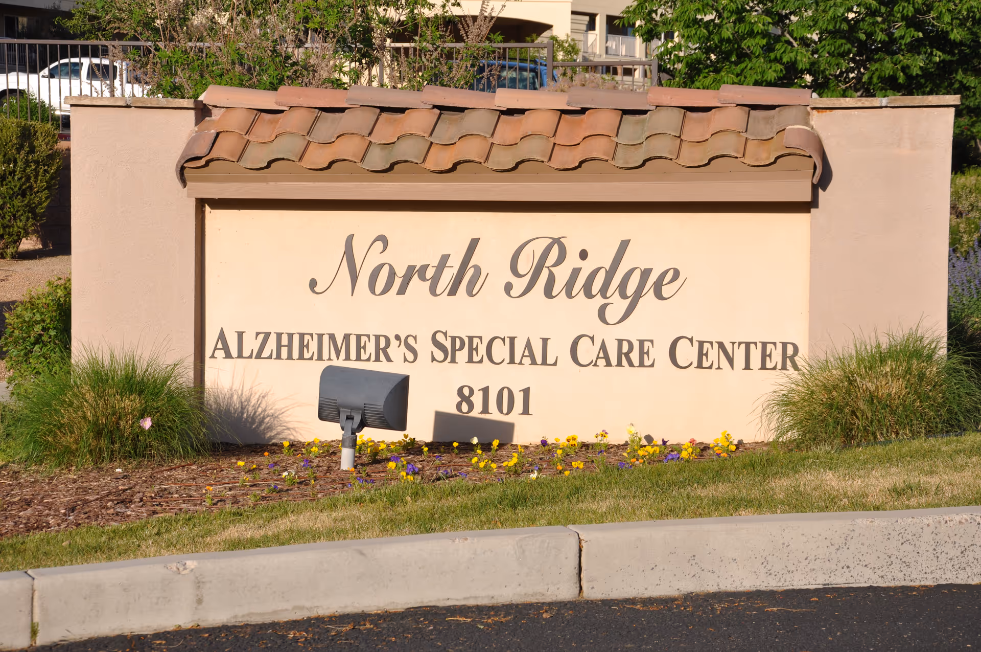 Exterior sign reads North Ridge Alzheimer's Specialized Care Center with landscaping.