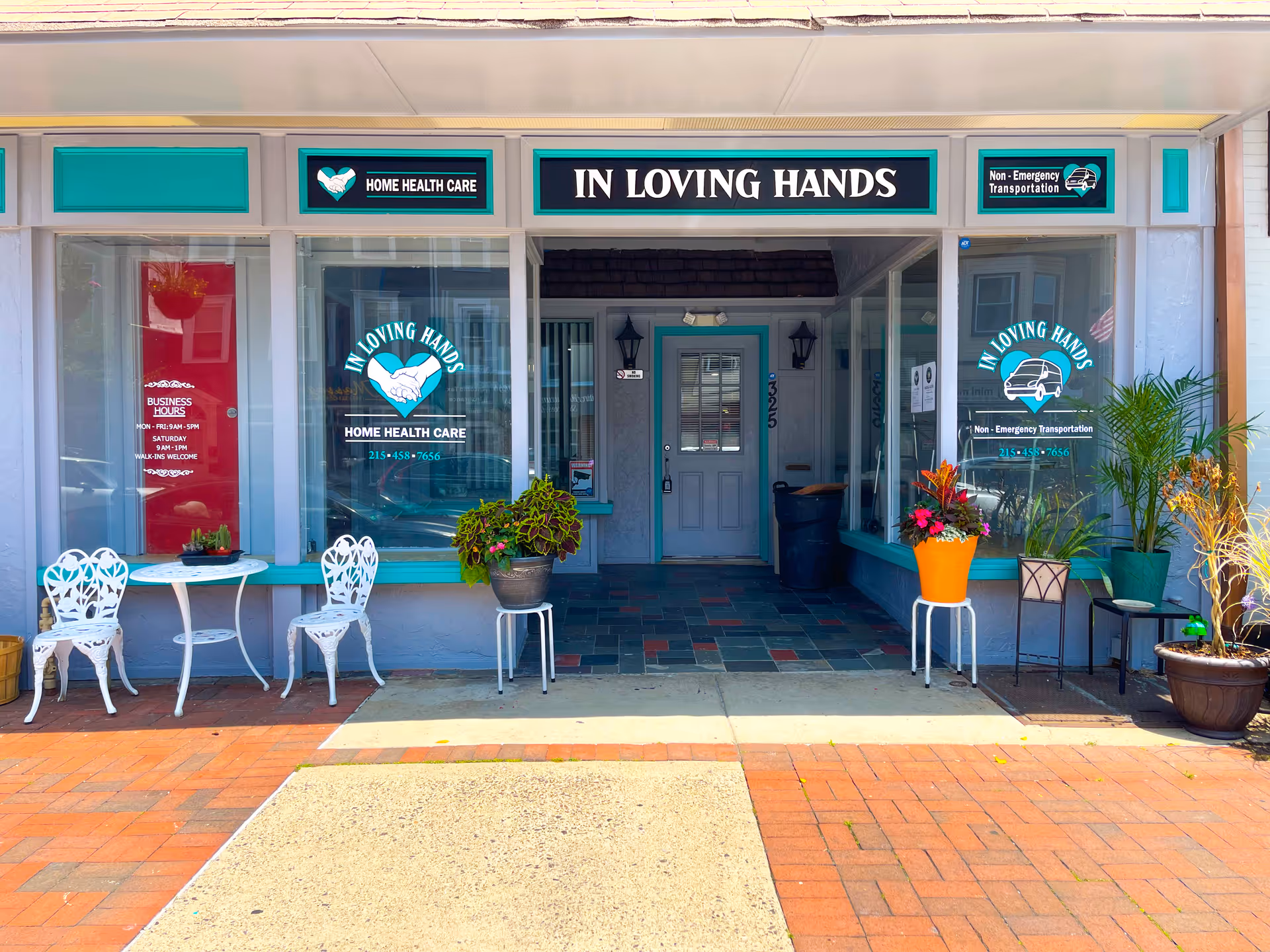 Storefront for In Loving Hands Home Health Care, with signage, glass doors, and potted plants.