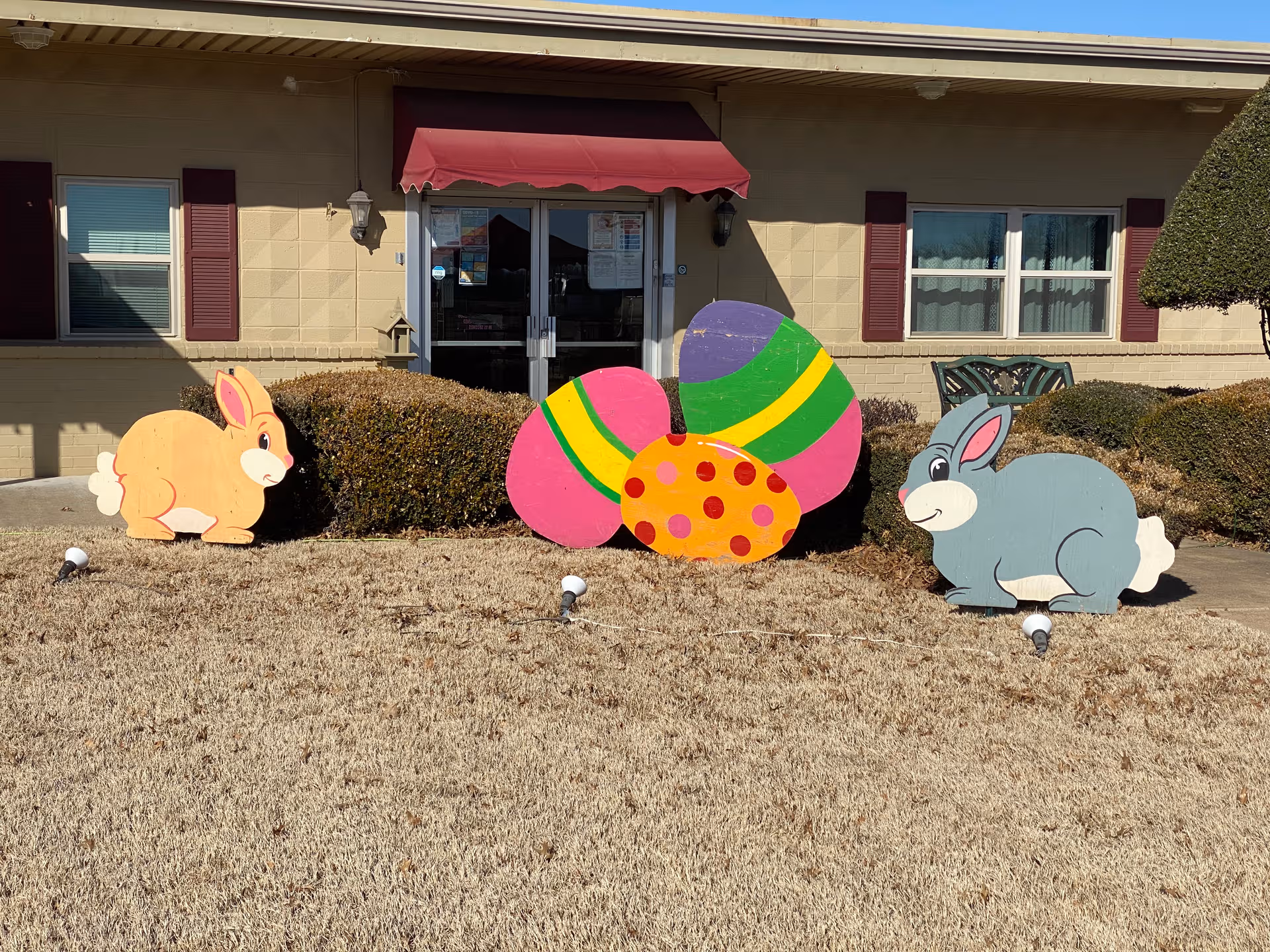 Front entrance of Cedarcrest Care Center with colorful Easter bunny and egg yard decor