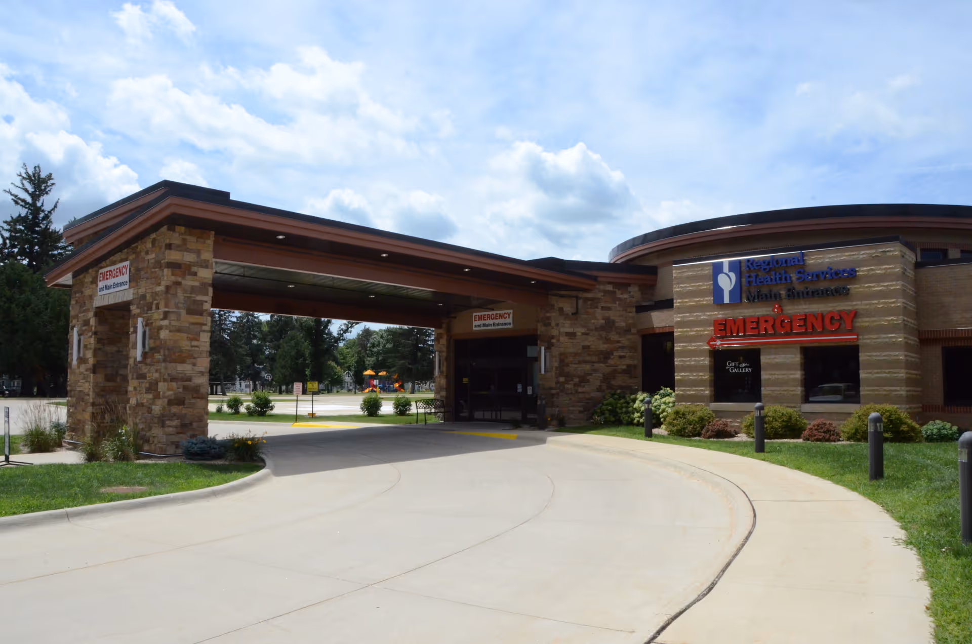 Front view of Regional Health Services facility with emergency entrance and stone pillars.