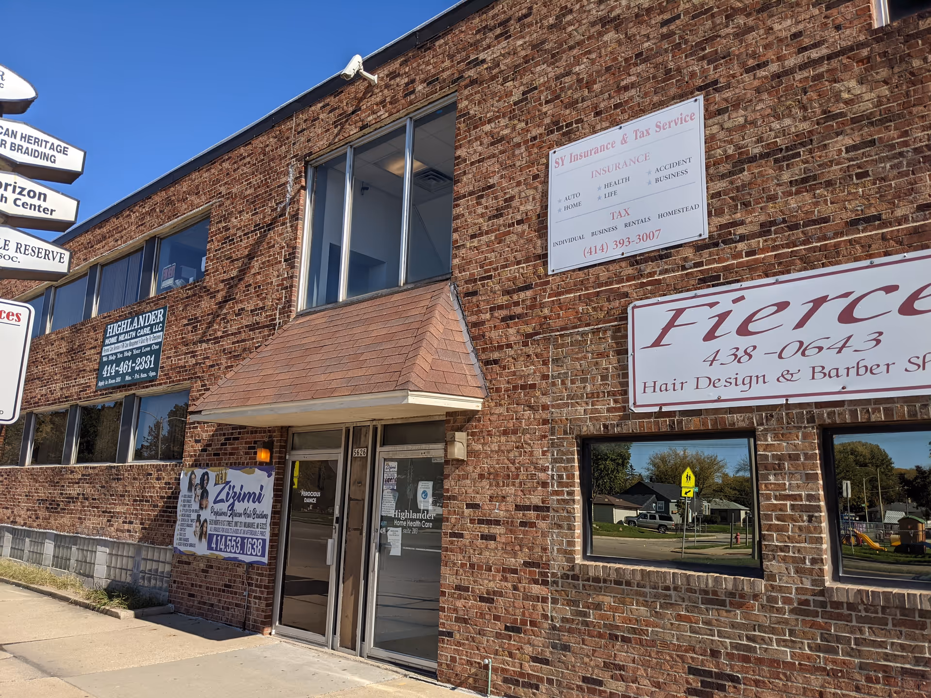 Brick commercial building with Highlander Home Health Care signage and storefronts.