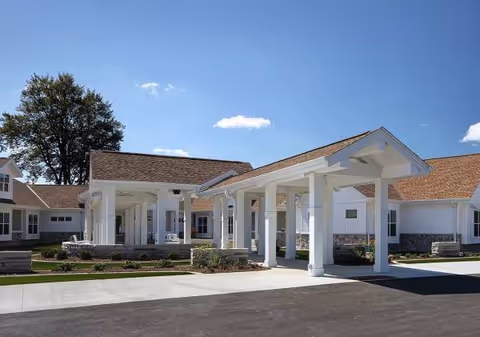 Front exterior of Cedar Lake Campus building with white columns and entrance drive.