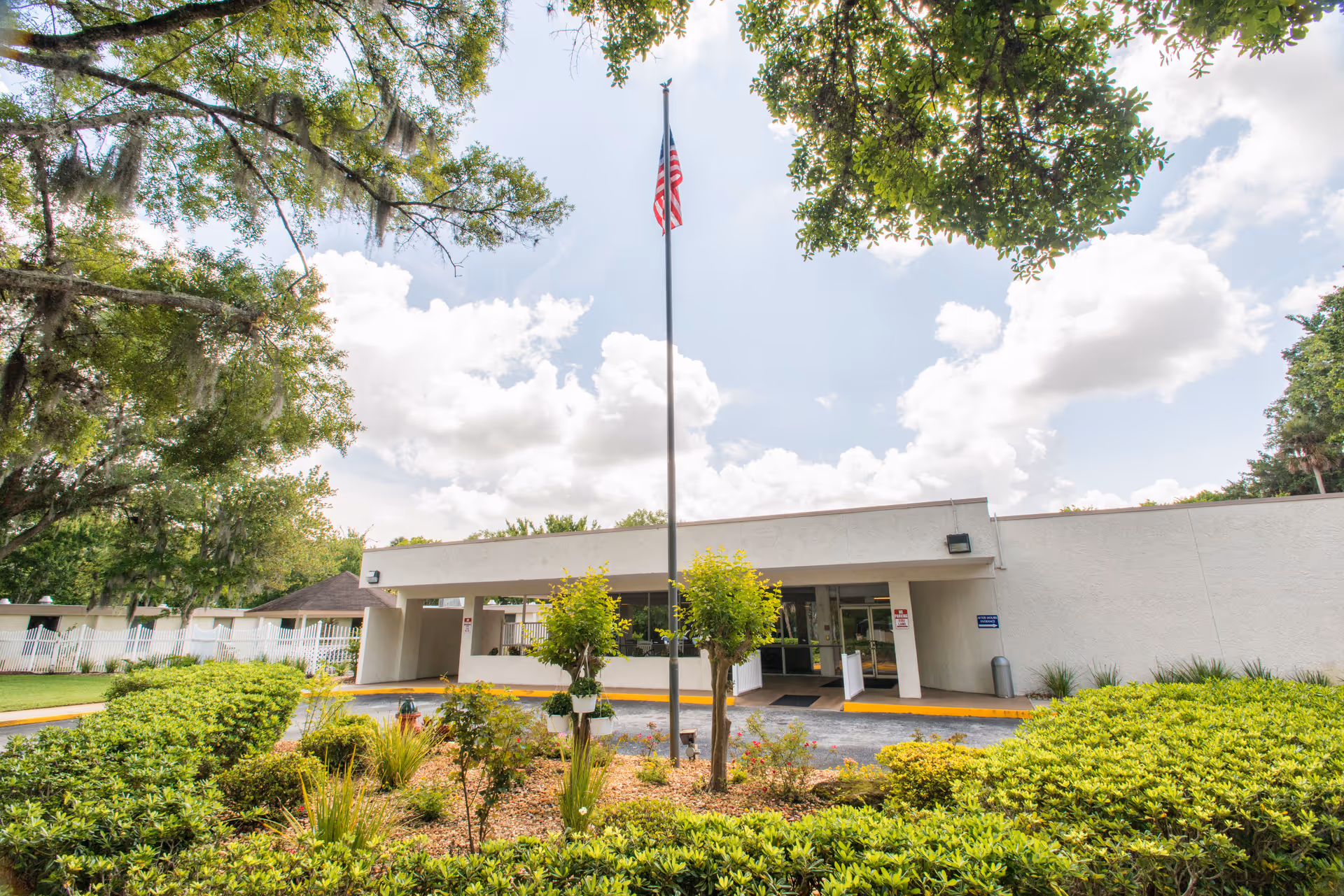 Exterior view of Daytona Beach Health and Rehabilitation Center entrance with flagpole and landscaping.