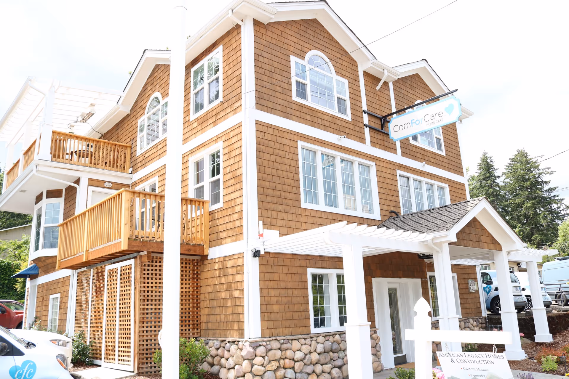 Front view of a brown shingle building with balconies and a ComForCare sign.