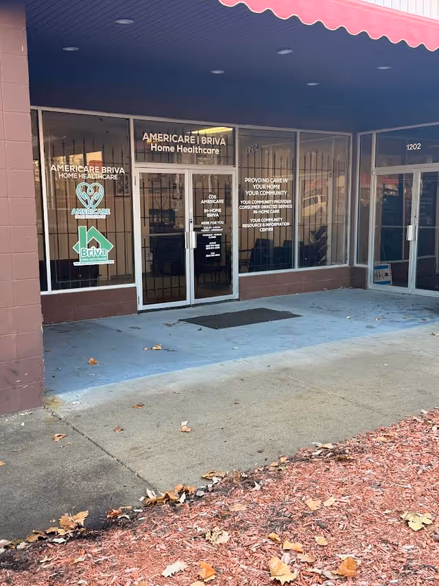 Front of a senior care storefront with glass doors and Americare Home Healthcare signage.