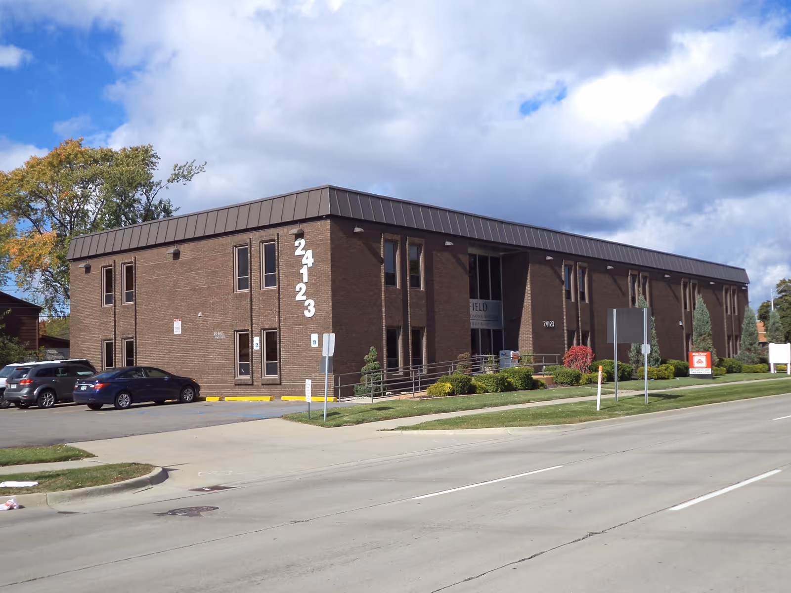 Brick senior care facility with parking lot, main entrance, and well-kept landscaping.