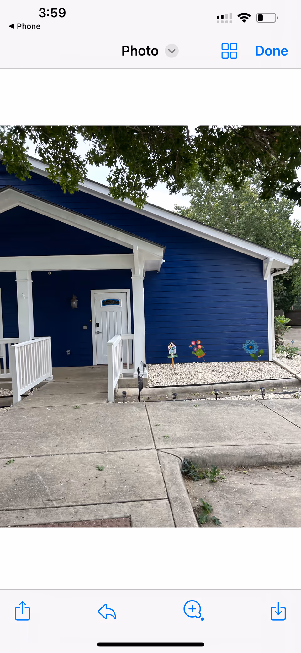 Front entrance of a blue senior living building with a small porch and walkway.