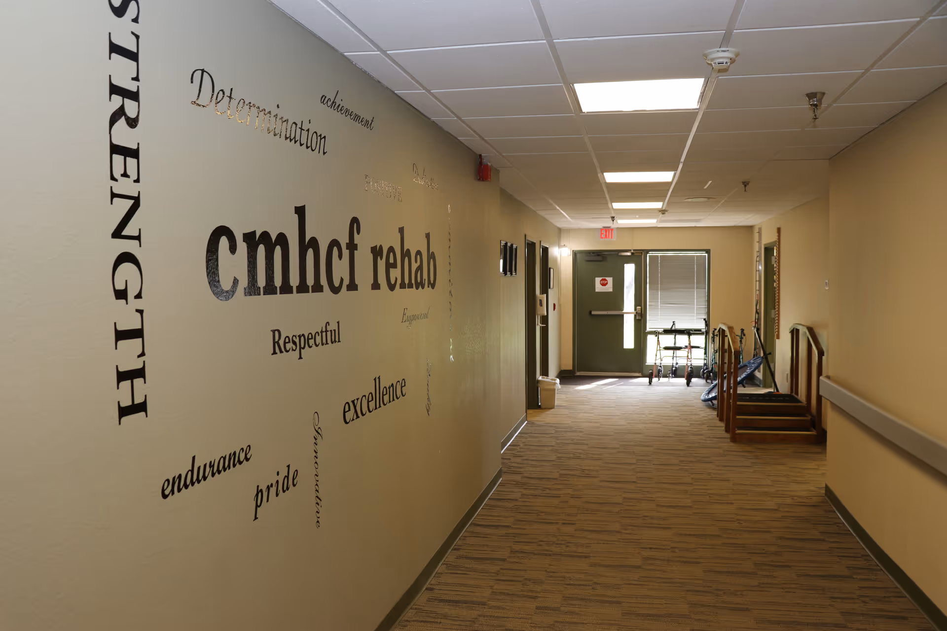 Interior hallway in a senior living facility featuring rehab-themed wall art.