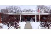 Front view of Scenery Hill Healthcare and Rehabilitation Center in snowy winter, with entrance walkway.
