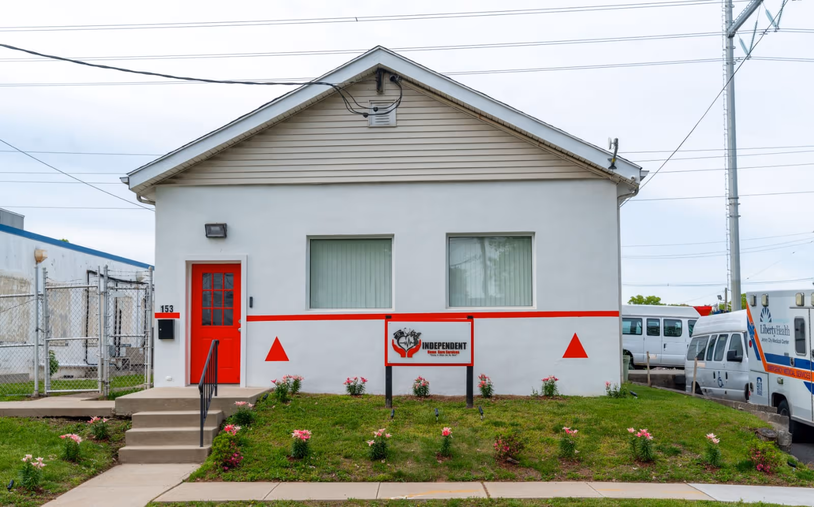 Small white building with red door and sign reading Independent Home Care Services.