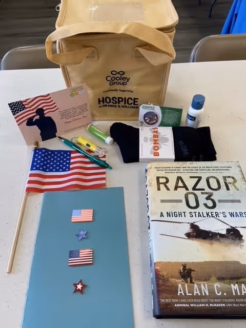 Tabletop display featuring Hospice of Orange and Sullivan Counties bag and assorted items.