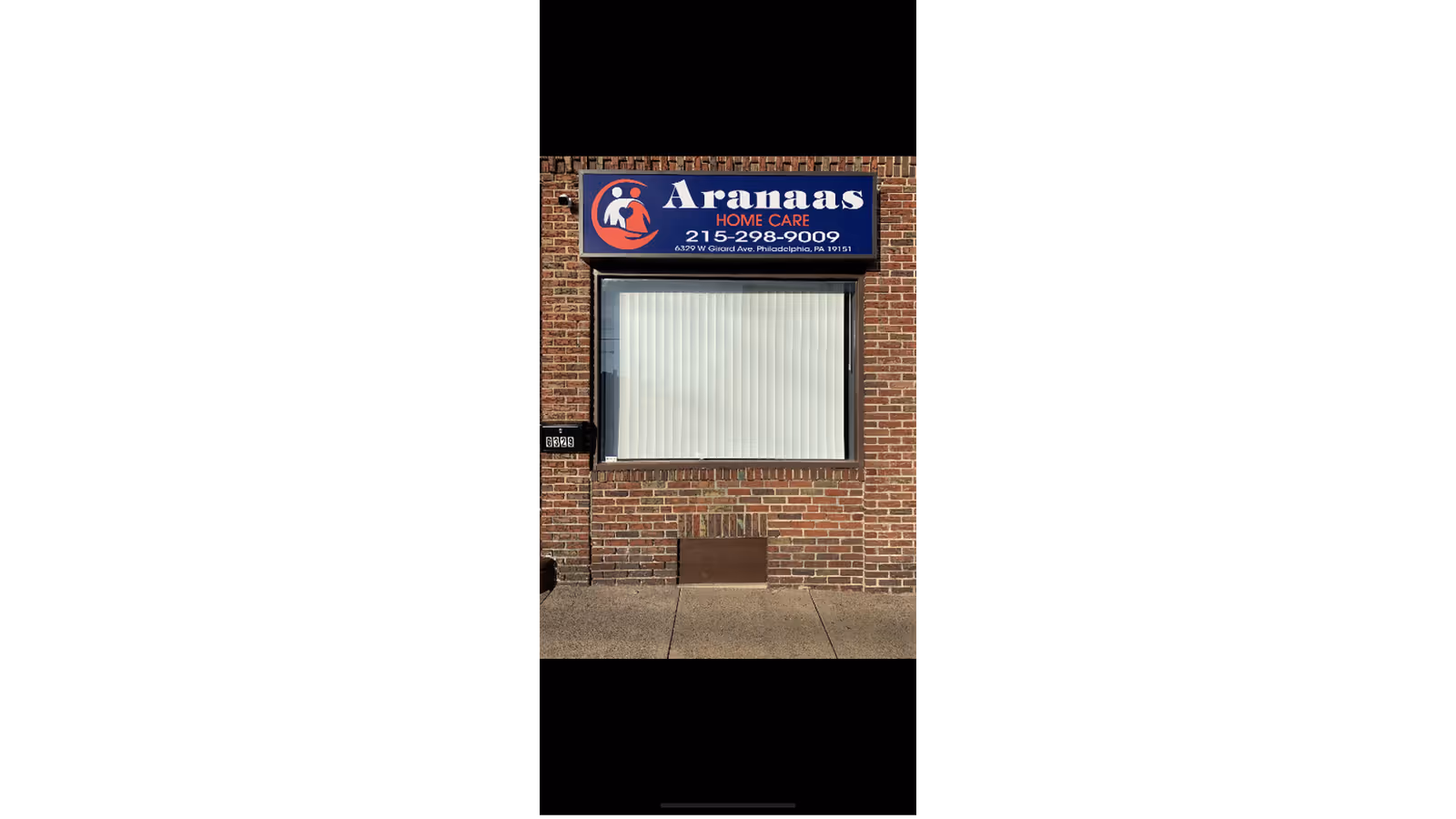 Brick storefront with Aranaas Home Care sign and a large window