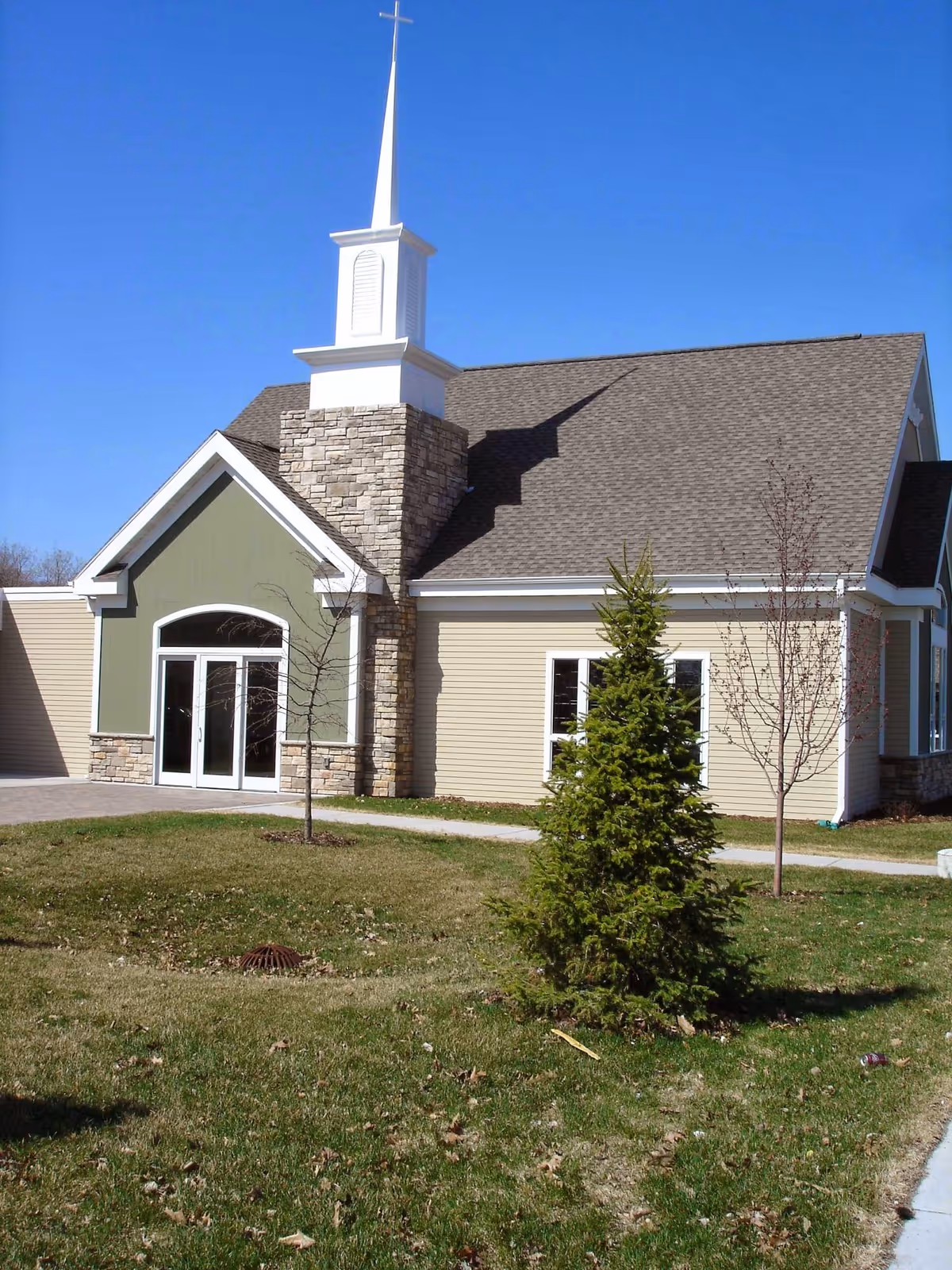 Front exterior view of a senior living facility with stone accents and blue sky.