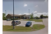 Front exterior of Windsor Care Center with parked cars and a driveway.