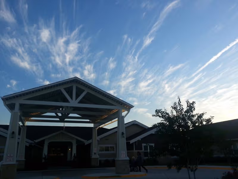 Front entrance canopy of Highland Springs Senior Living Community under a clear blue sky.