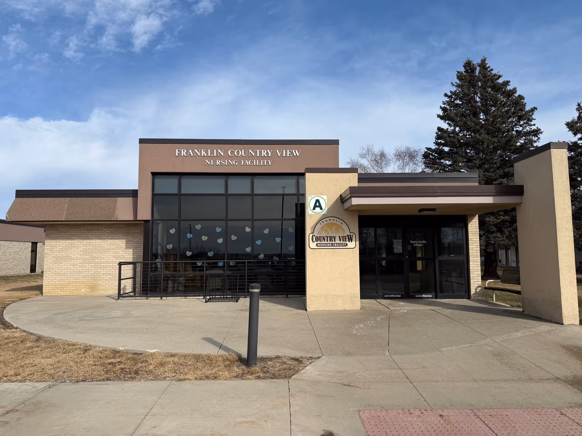 Front view of Franklin Country View Nursing Facility with glass entry and ramp