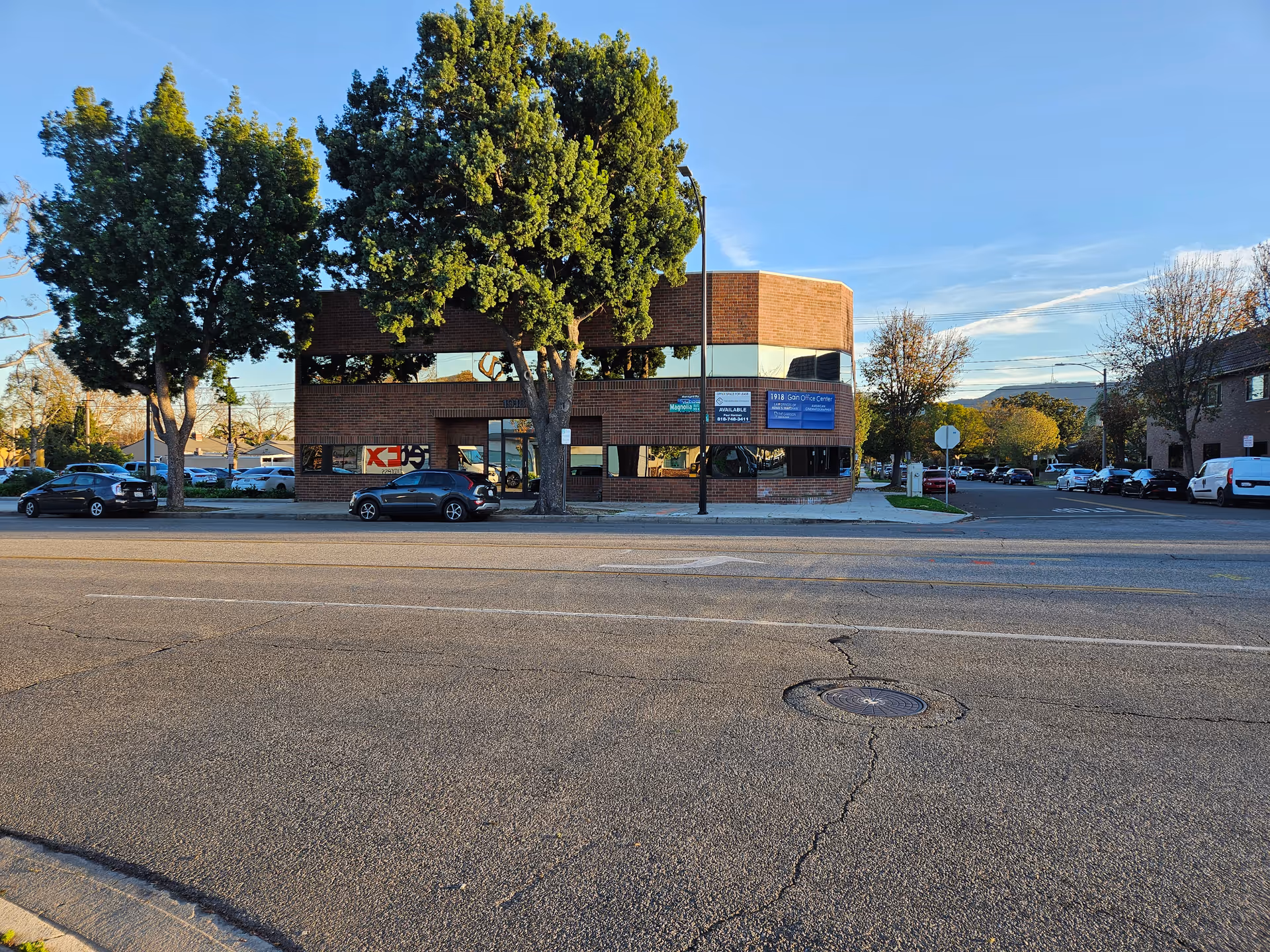 Exterior view of All Elite Home Health, Inc. building on a street with cars and trees.