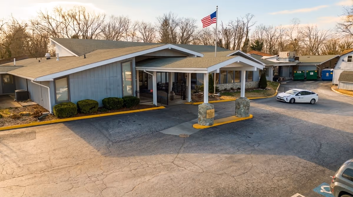 Exterior view of Holston Rehabilitation and Care Center with a covered entrance and flag.