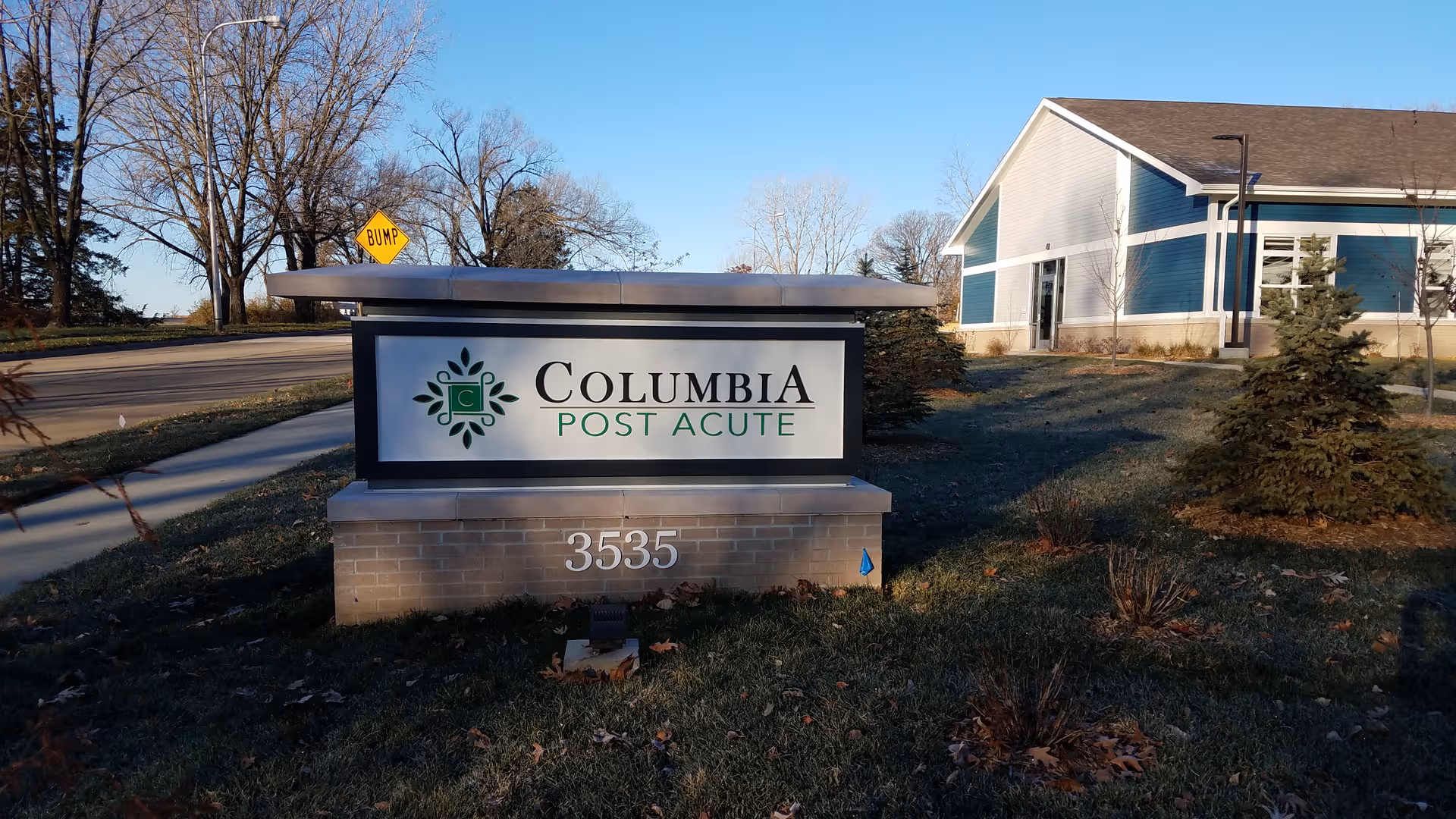 Exterior view of Columbia Post Acute sign and building in the background.