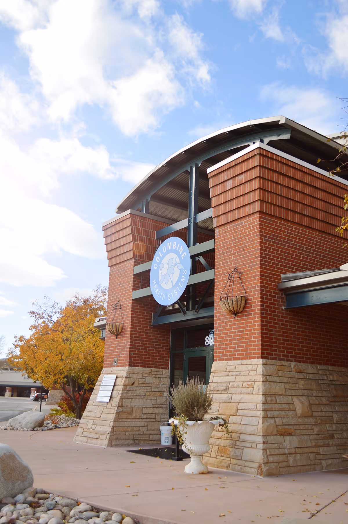 Exterior view of a Columbine Health Systems facility entrance with brick walls and planters.
