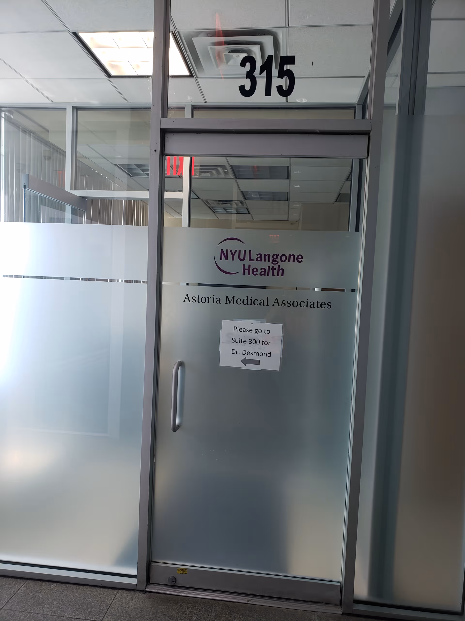Frosted glass door with NYU Langone Health Astoria Medical Associates sign in a corridor