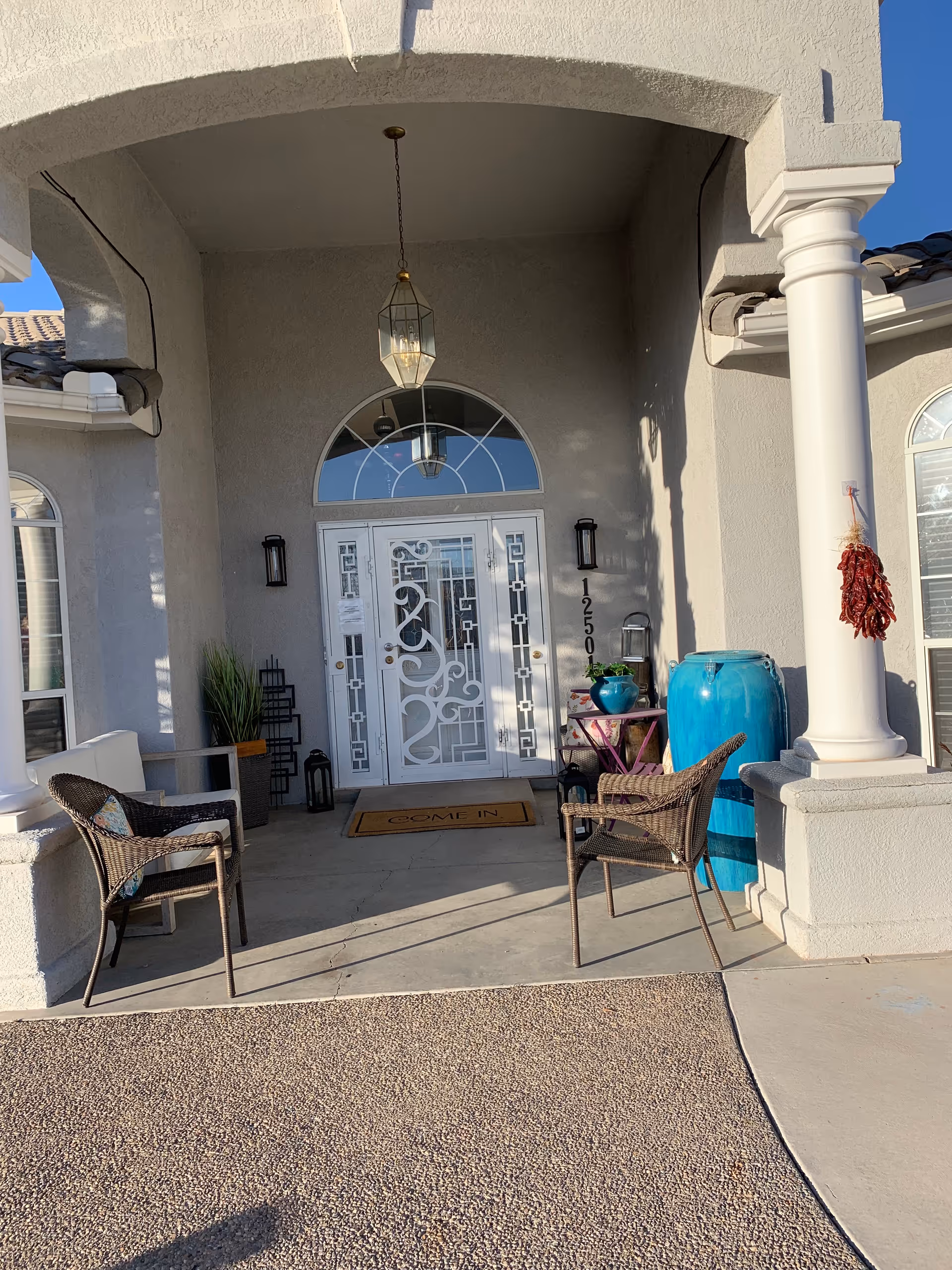 Front entrance of Sandia View Assisted Living with chairs on a covered porch.