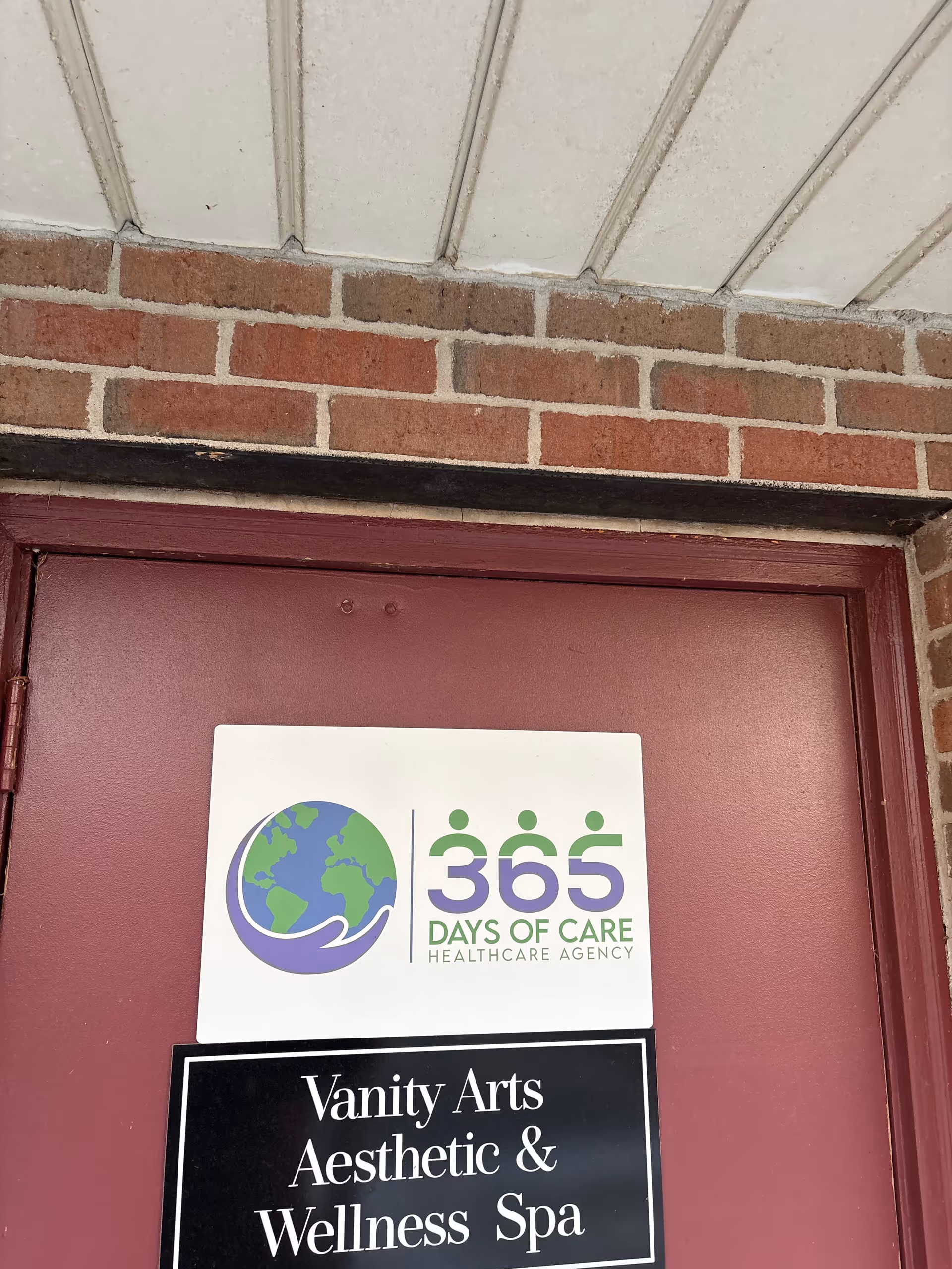 Brick exterior doorway with 365 Days of Care sign and Vanity Arts Wellness Spa sign.