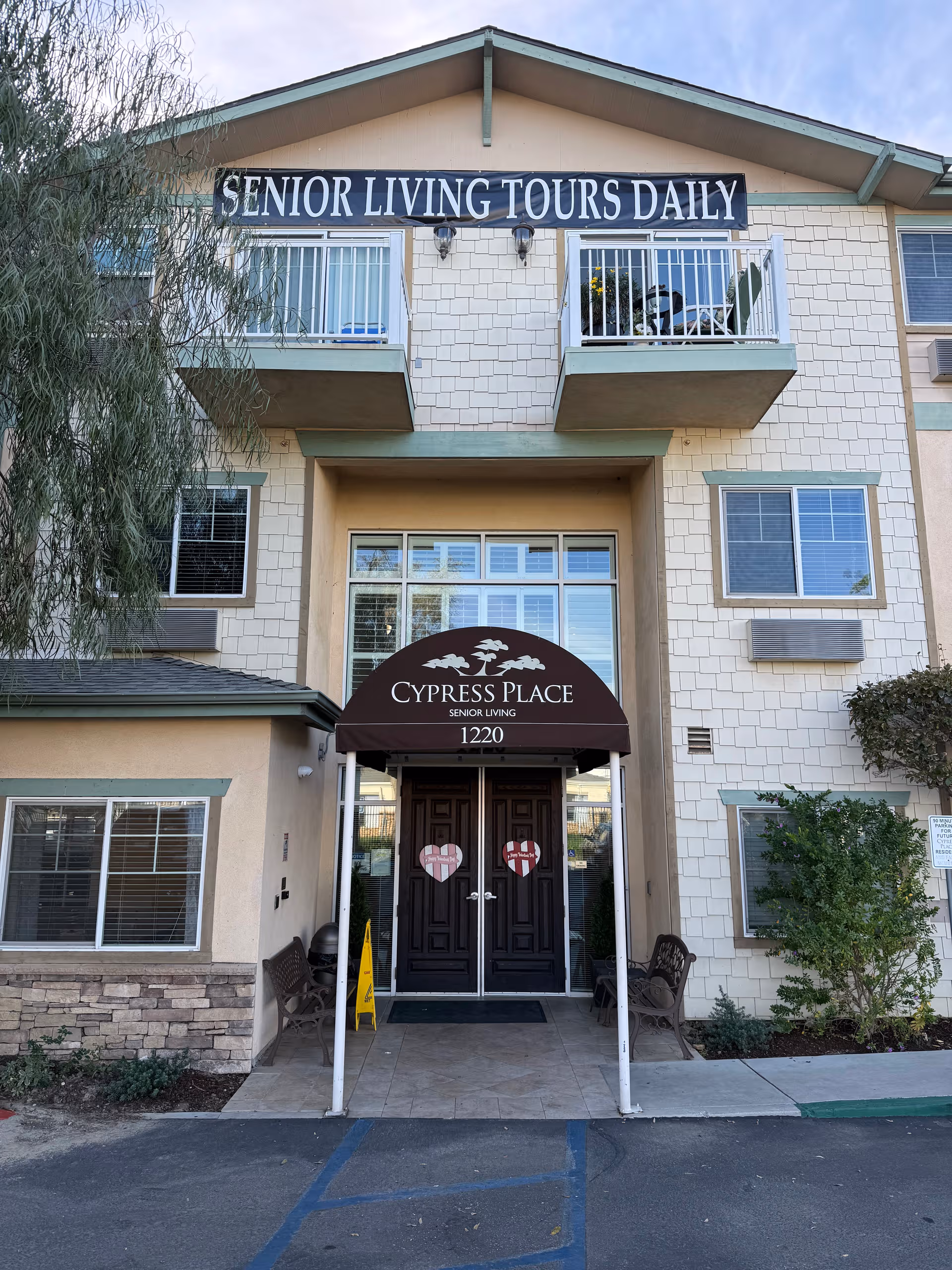 Exterior view of Cypress Place senior living with entrance canopy and seating.