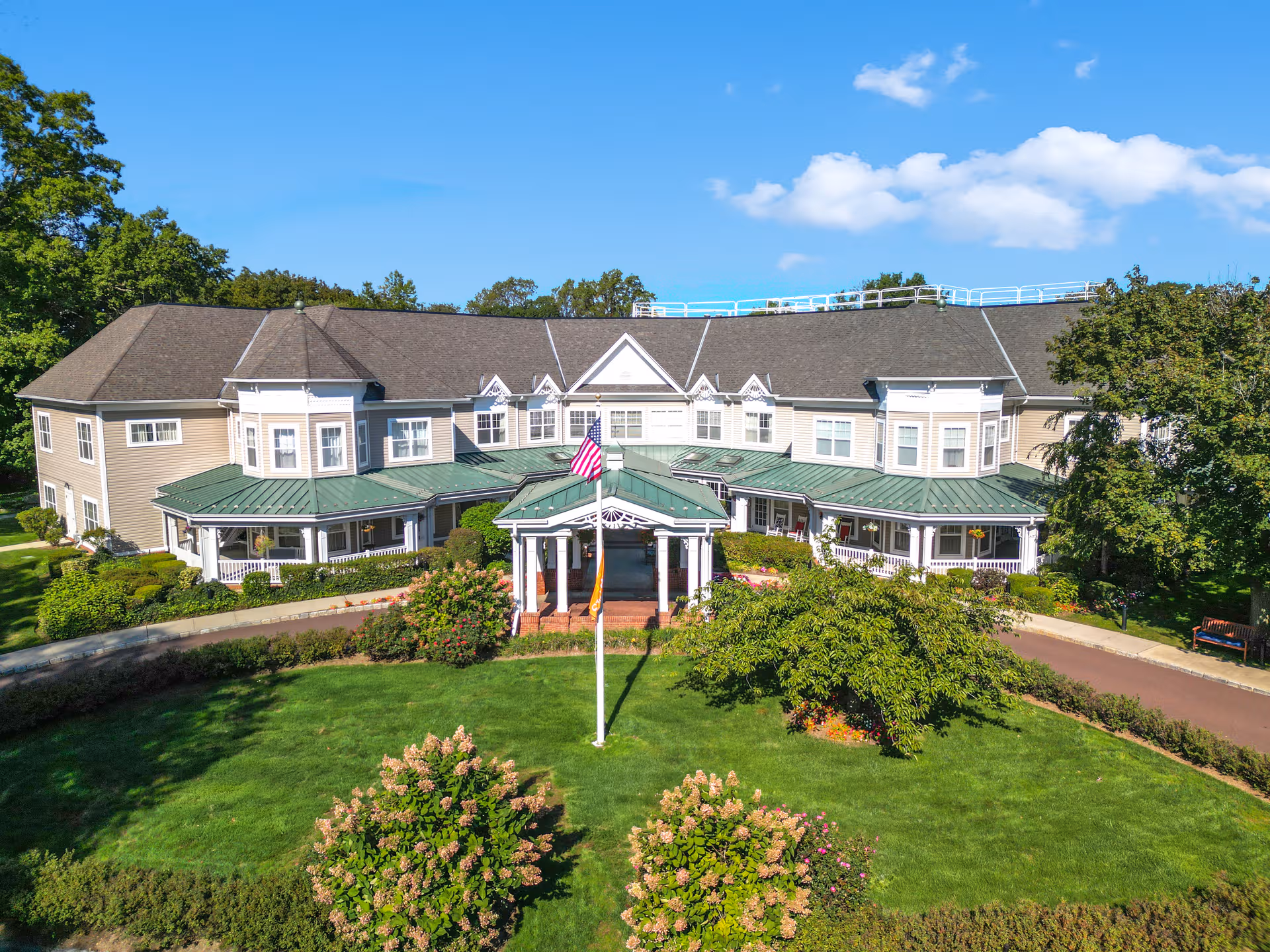 Sunrise at Fleetwood senior living facility, front view with manicured lawn and flagpole.