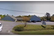 Exterior view of Palmetto Village of Chester with parked cars in front.