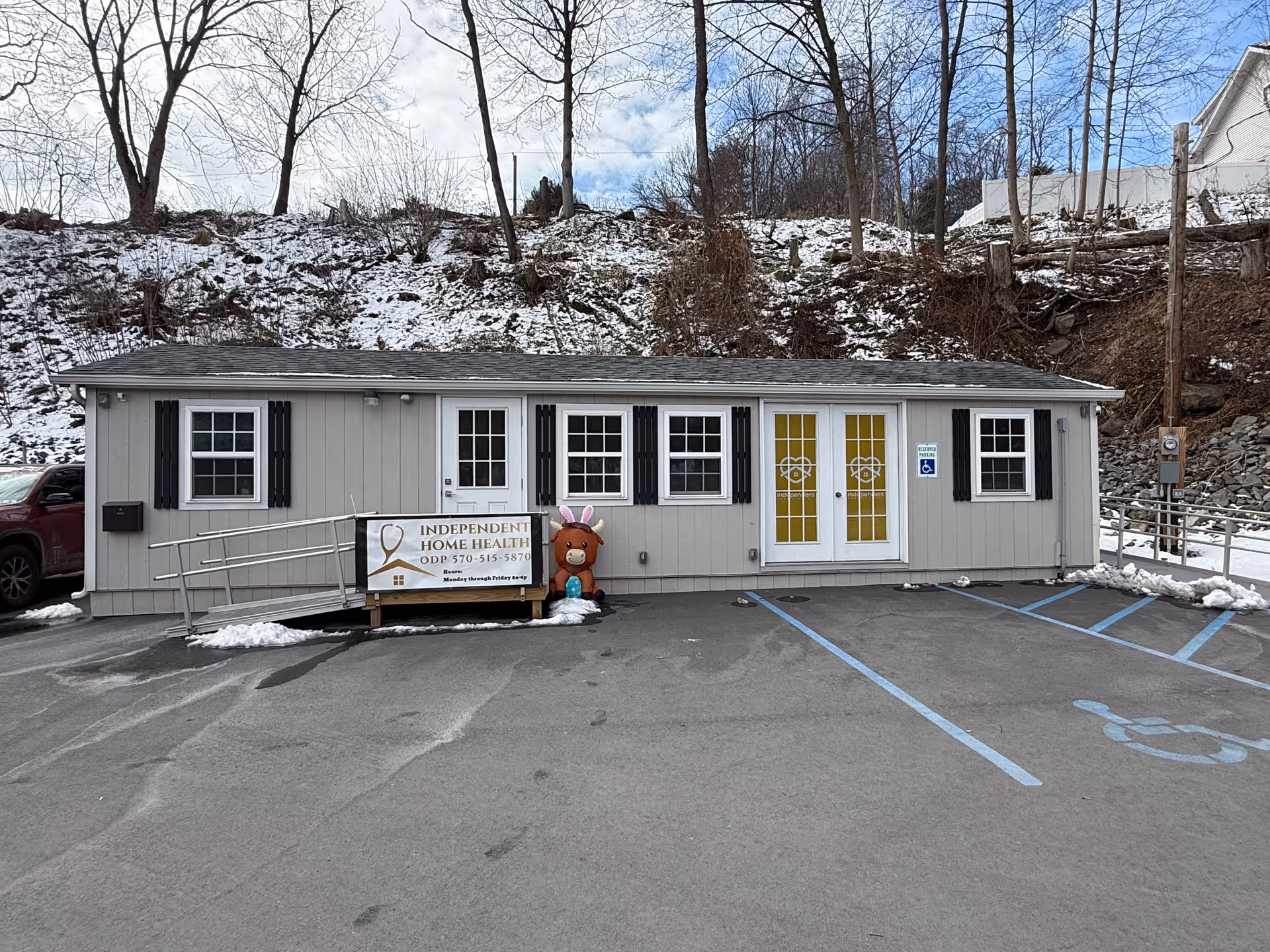 Small gray front building with yellow doors, ramp, and a banner reading Independent Home Health ODP