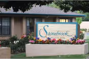 Exterior view of Stonebrook Healthcare Center with a landscaped entrance sign.