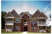 Front exterior view of a brick senior living building with balconies and a central arch.