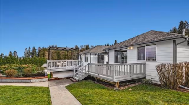 Exterior view of Christy Tender Care Adult Family Home showing white siding and wooden decks.