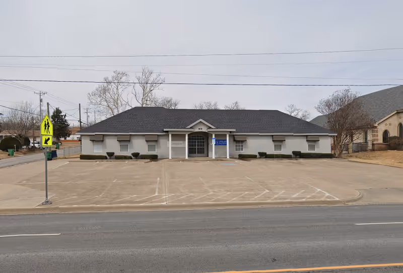 Front view of a Solaris Healthcare building with a large parking lot in front.