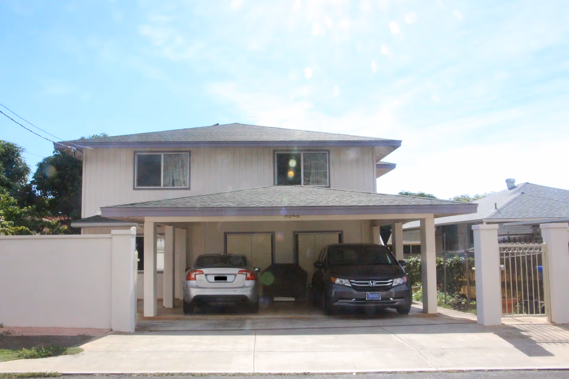 Two-story Yaying House exterior with a covered carport and parked cars.