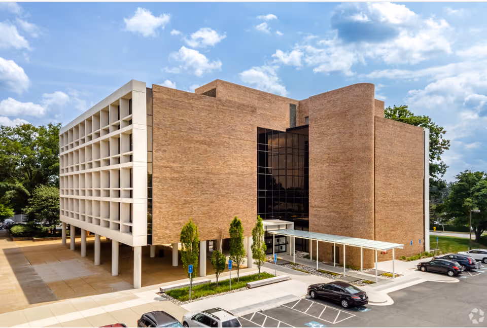 Modern brick senior living facility exterior with glass entrance and parking