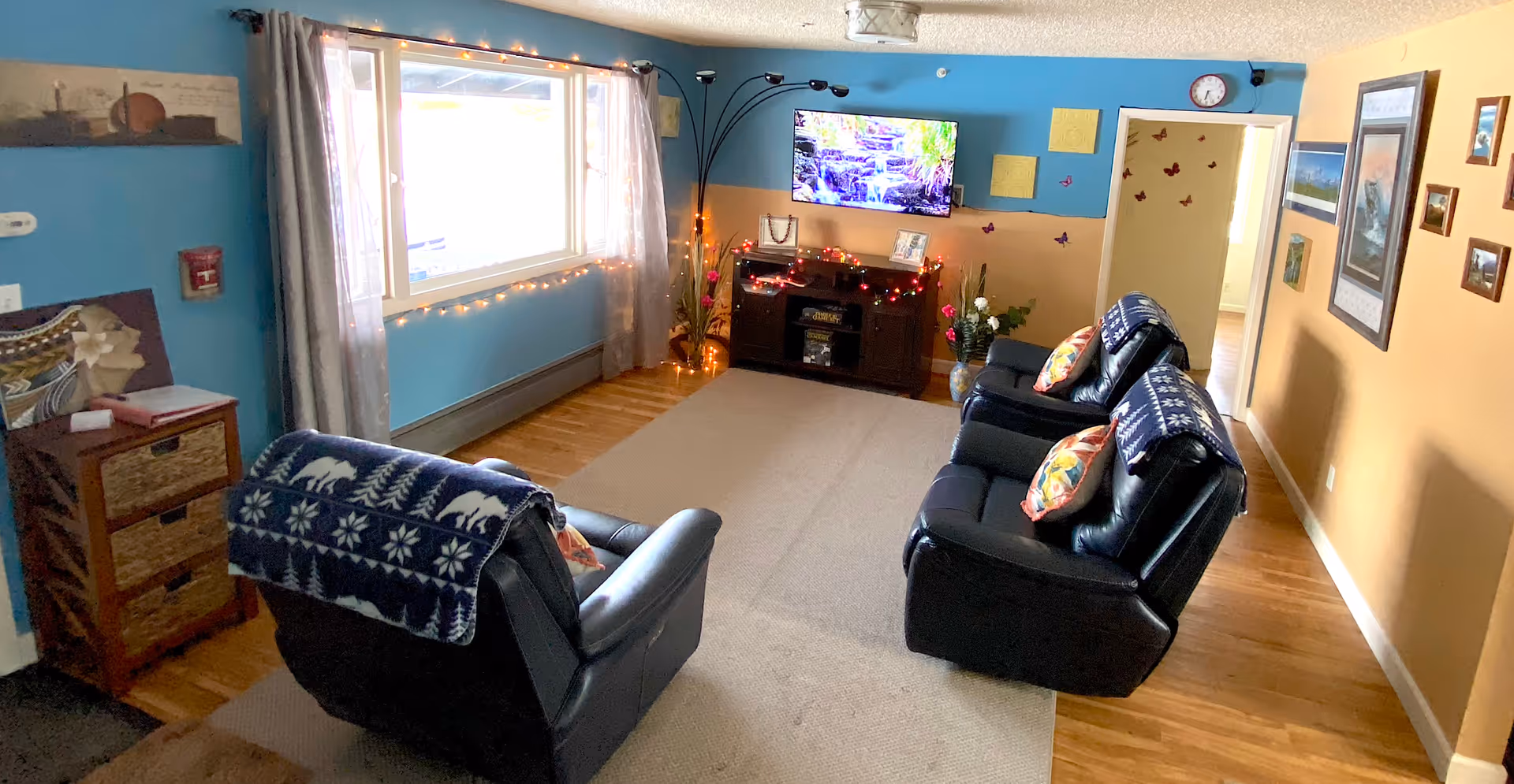 Cozy senior living room with two recliners, a TV, and colorful two-tone walls.