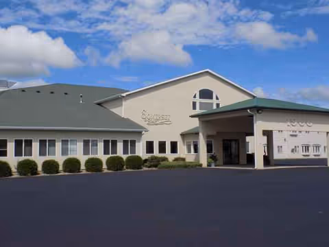 Exterior view of Somerset Court senior living facility with entrance canopy and shrubs.