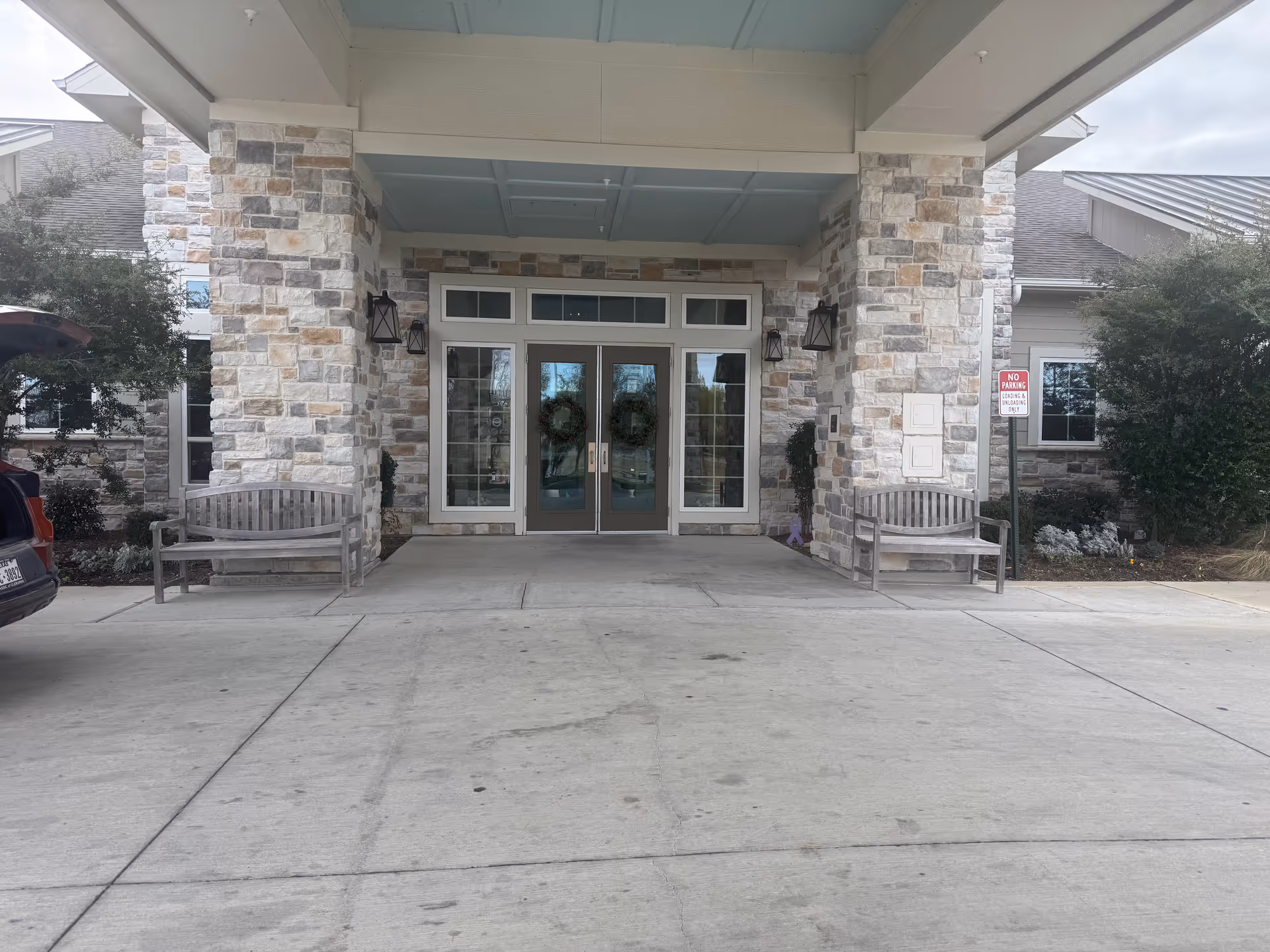 Front entrance of West Fork at Weatherford with stone facade, glass doors, and benches.
