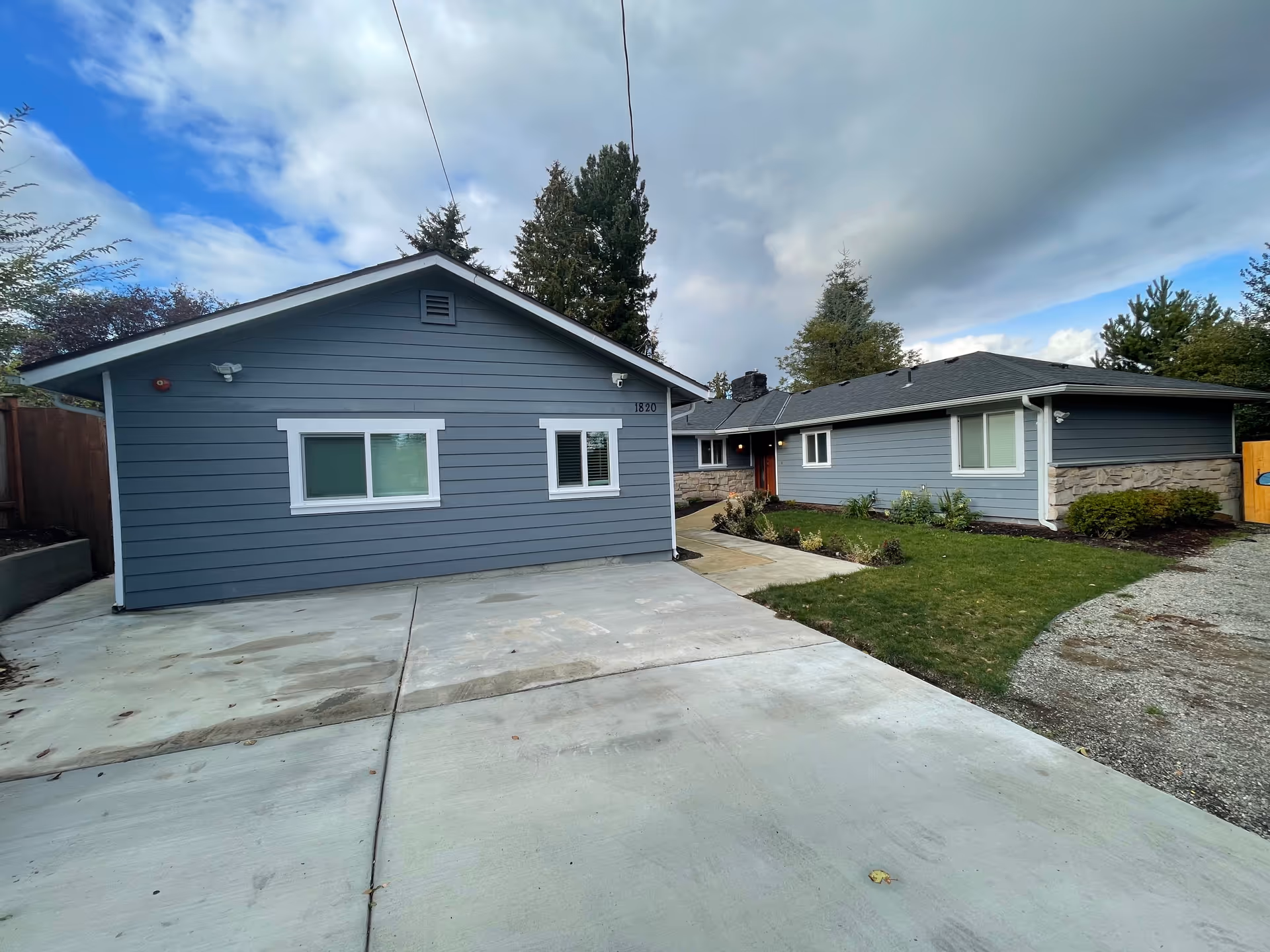 Two blue-gray single-story buildings with driveways and small front yards.