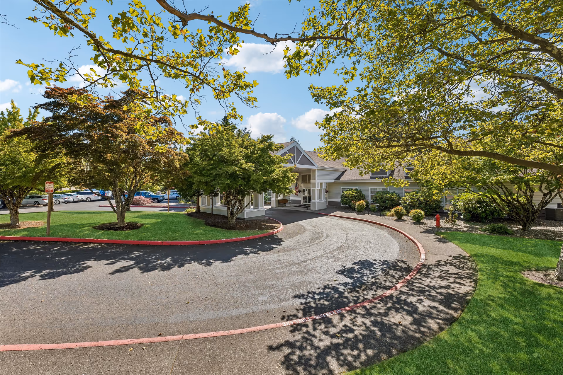 Curved driveway leads to the front entrance of a Gresham Pointe Senior Living building.