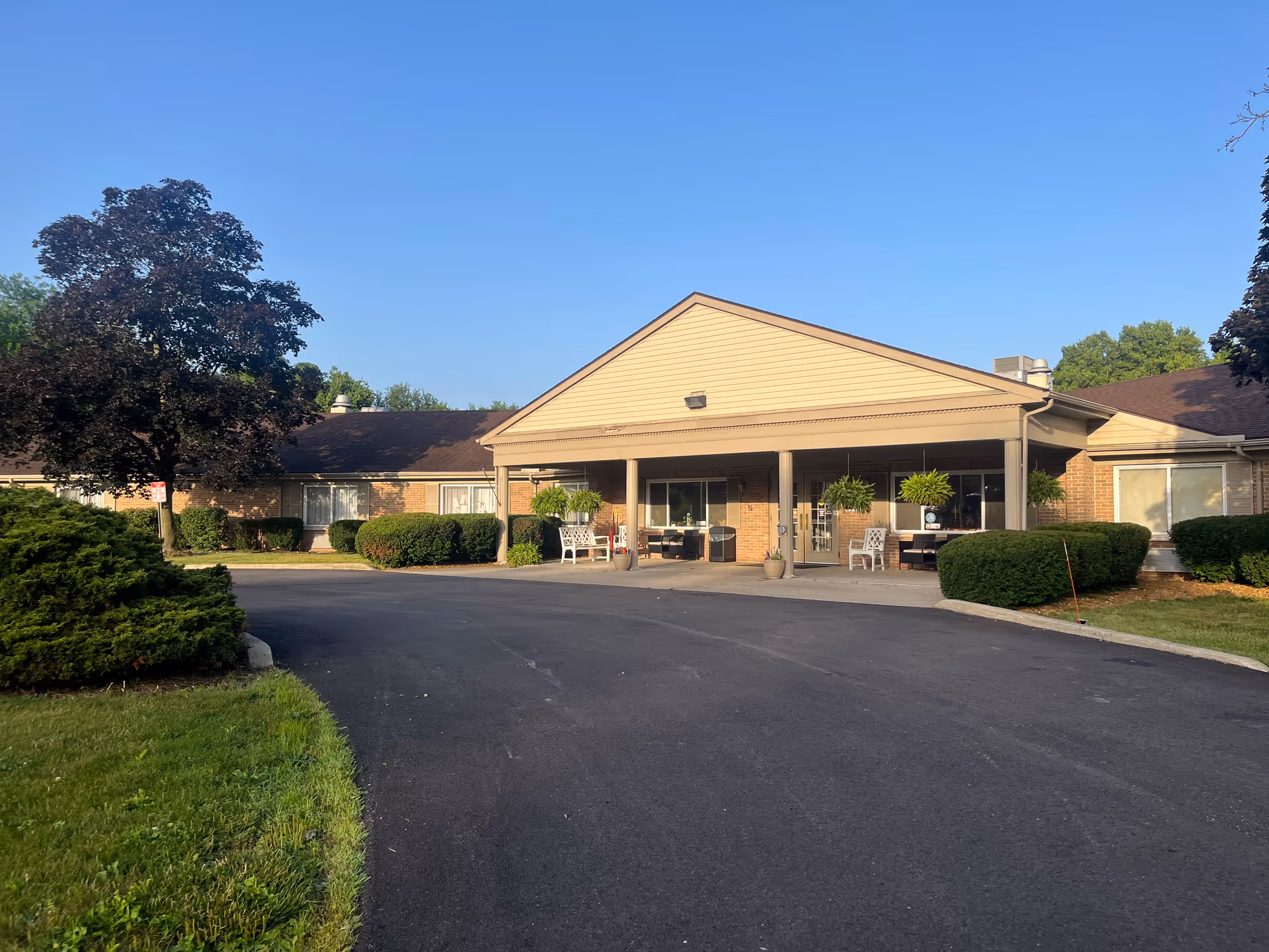 Front view of ProMedica Kettering senior living facility with covered entrance and seating.