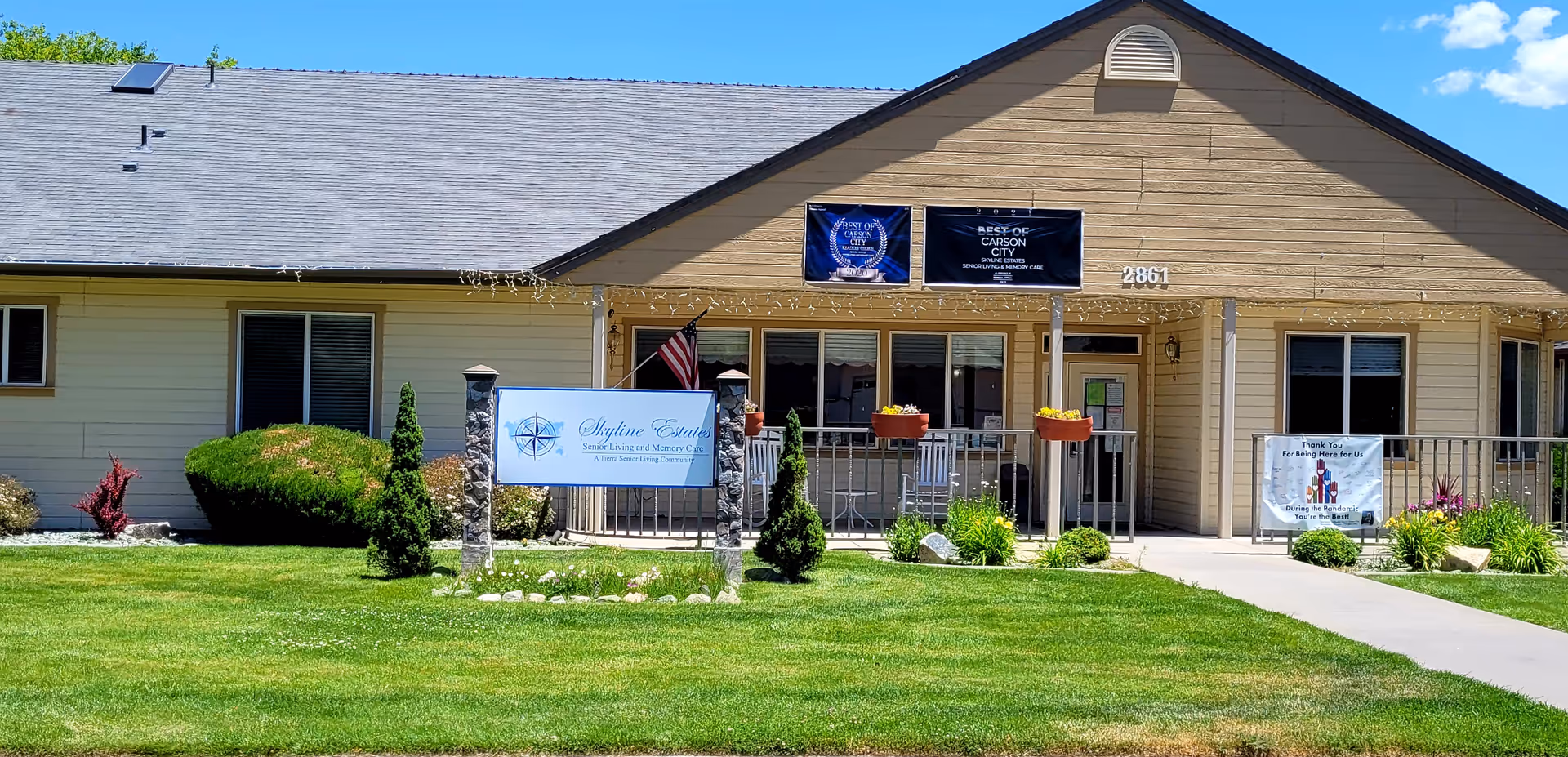Single-story senior living facility with signage, entrance ramp, and a well-kept lawn in front.
