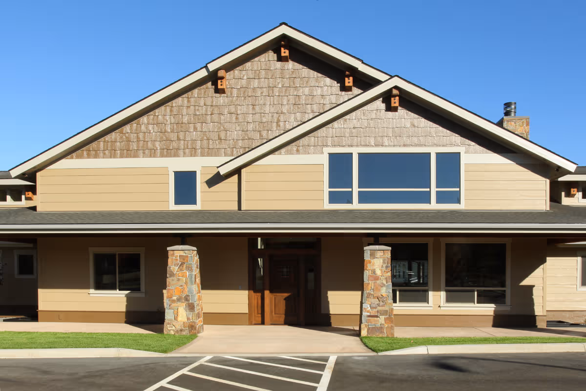 Exterior view of The Lodge at Fairway Forest building with stone columns and large windows.