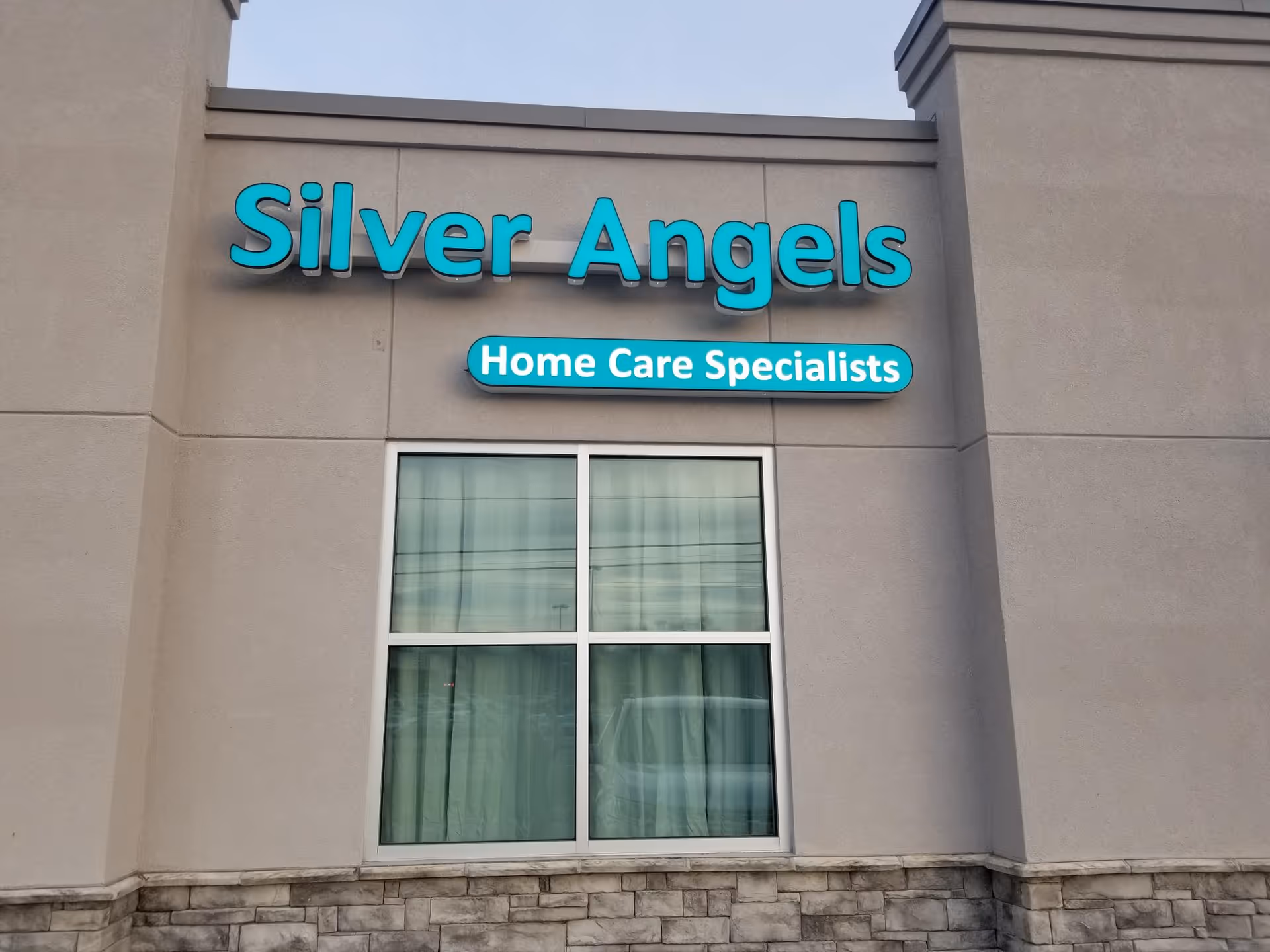 Exterior view of Silver Angels facility with teal Home Care Specialists sign above a window.
