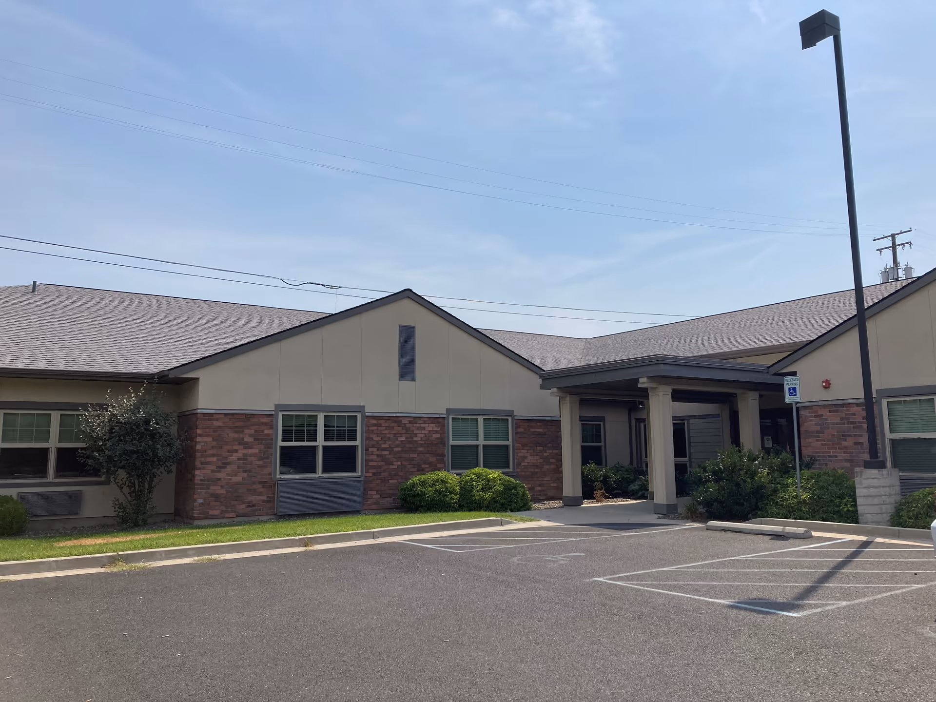Single-story senior care facility exterior with brick façade and a covered entrance.