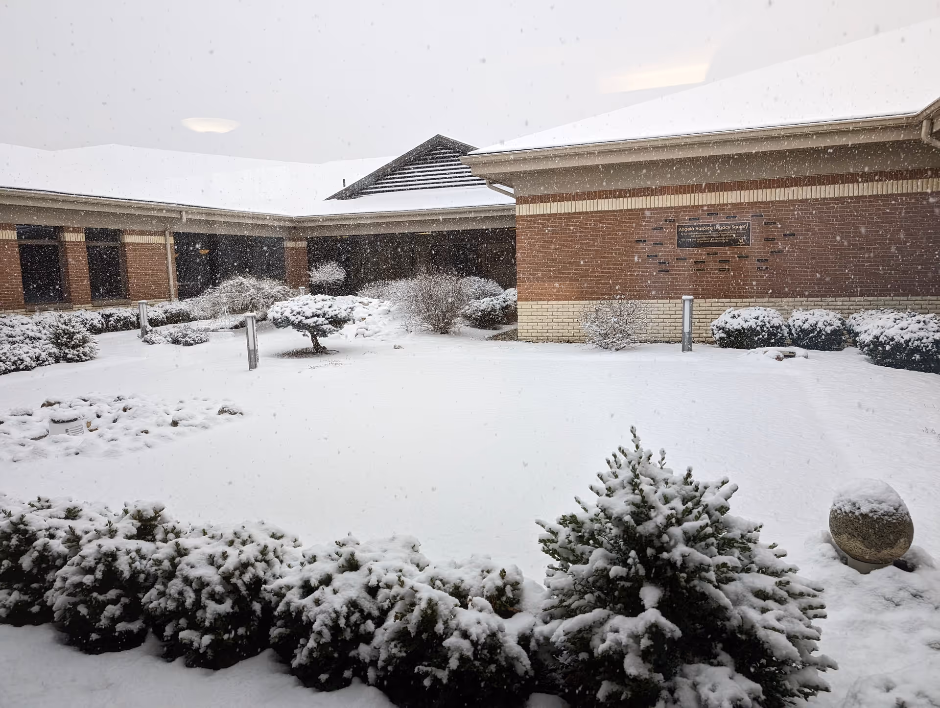 Snow covers the brick exterior courtyard at Angela Hospice.