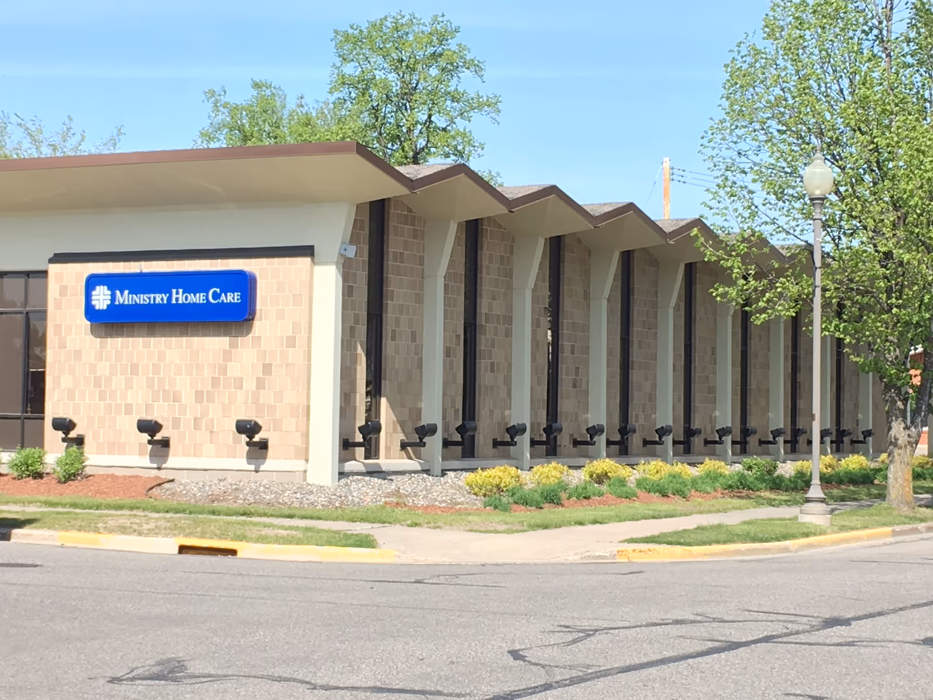 Exterior view of Ministry Home Care building with a blue sign on brick facade