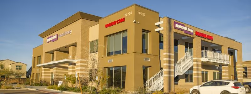 Two-story tan building labeled 'HonorHealth Outpatient Therapy - Happy Valley' with stairs and a parked car.